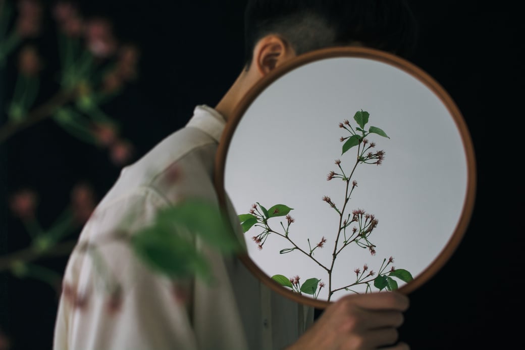 Man with Flowers Reflecting in Mirror